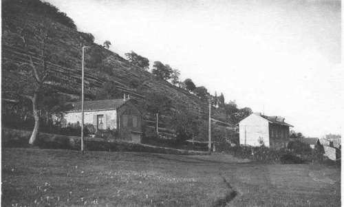 Prés et maisons au pied d’une colline