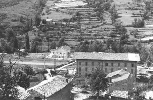 Grand bâtiment au centre du bourg, terrasses au-dessus